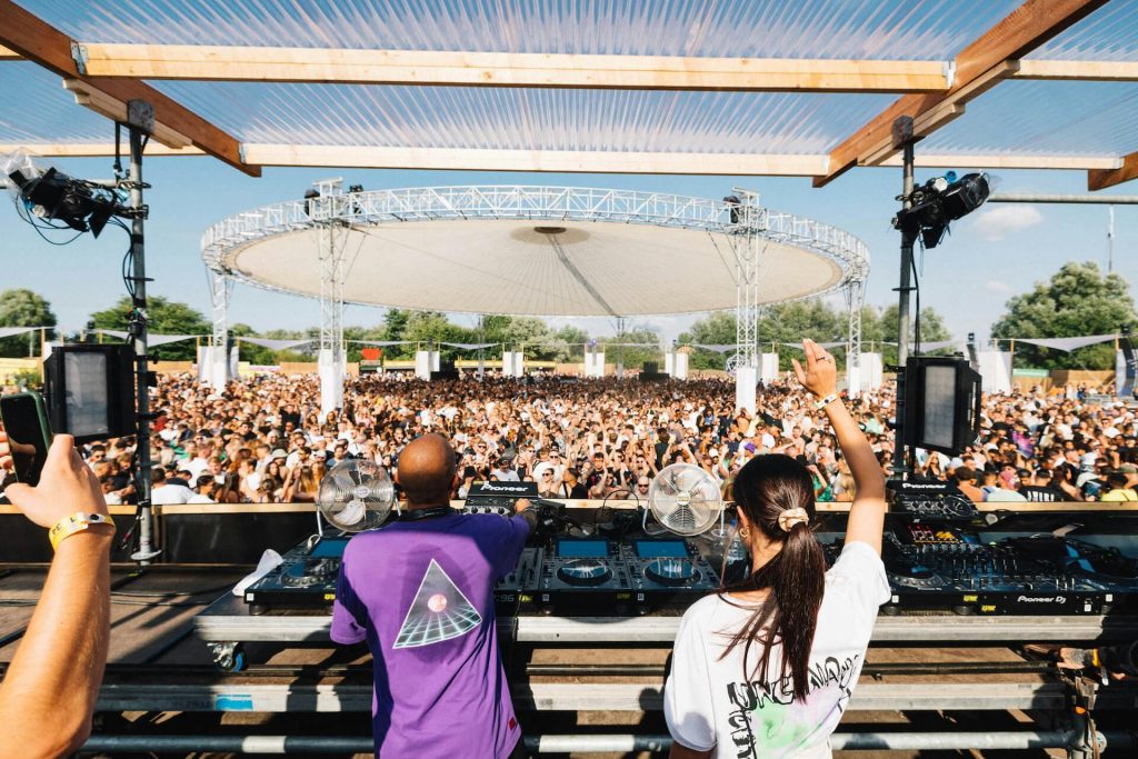 Fans dance under neon lights at harmony of strafwerk 2024